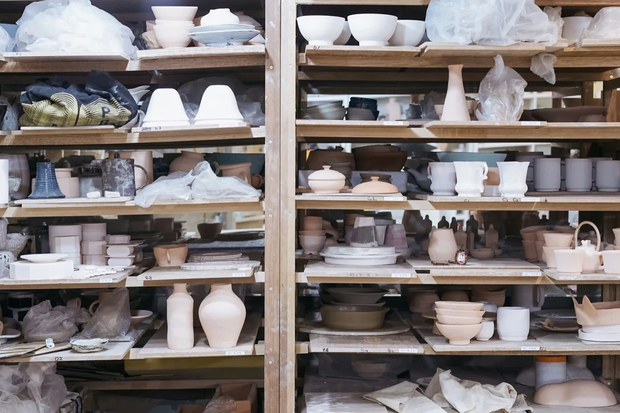 Shelves filled with ceramic pieces and works in progress in a studio archive.